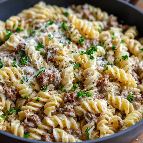 A bowl of pasta with meat and cheese.