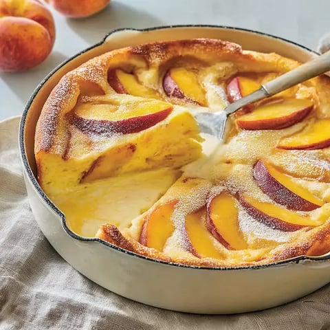 A slice of pie with peaches and a spoon.