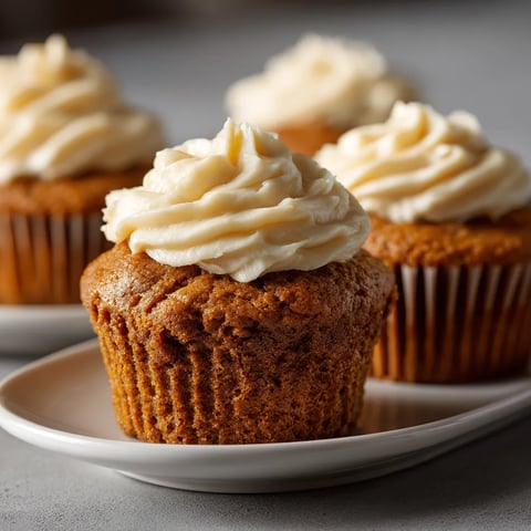 Three cupcakes with white frosting.