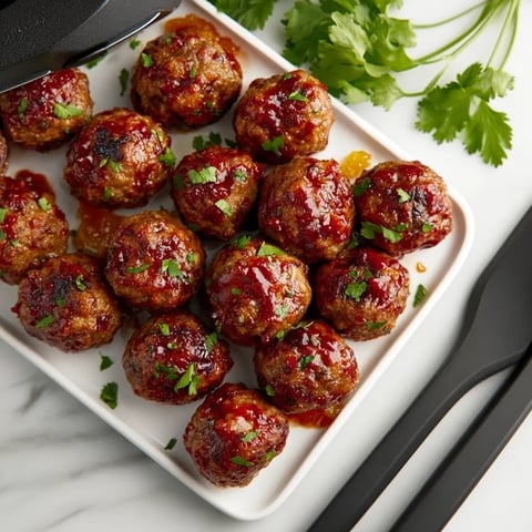 A plate of meatballs with sauce.